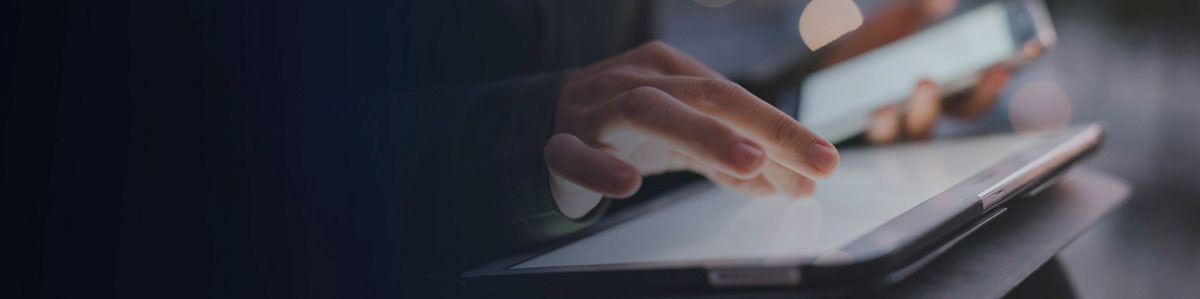 a hand typing on a keyboard, another holding a smartphone