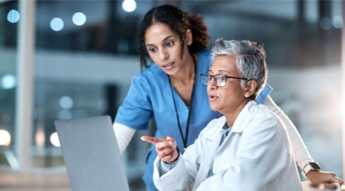 A nurse and doctor looking at a laptop